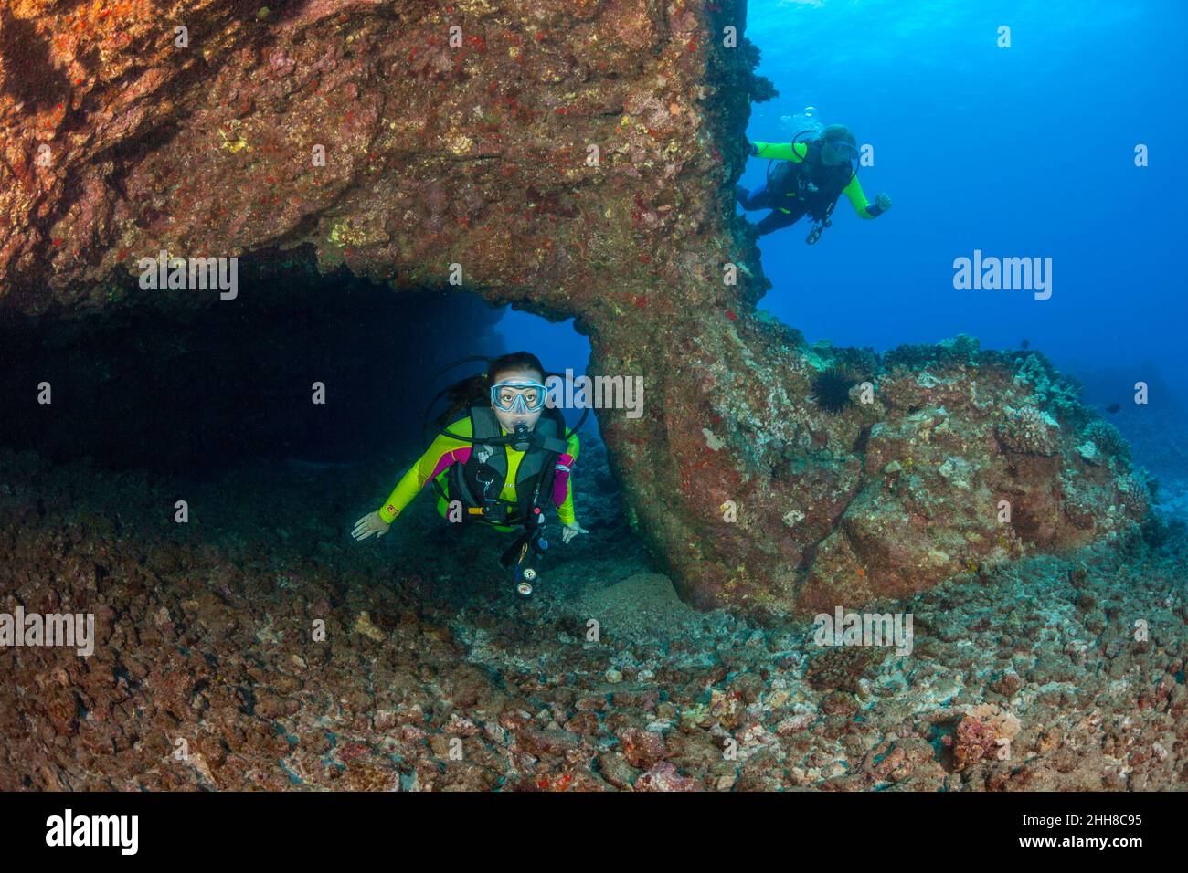 Subacquei (MR) raffigurati intorno ad un arco di lava al largo dell'isola di Lanai, Hawaii. Foto Stock