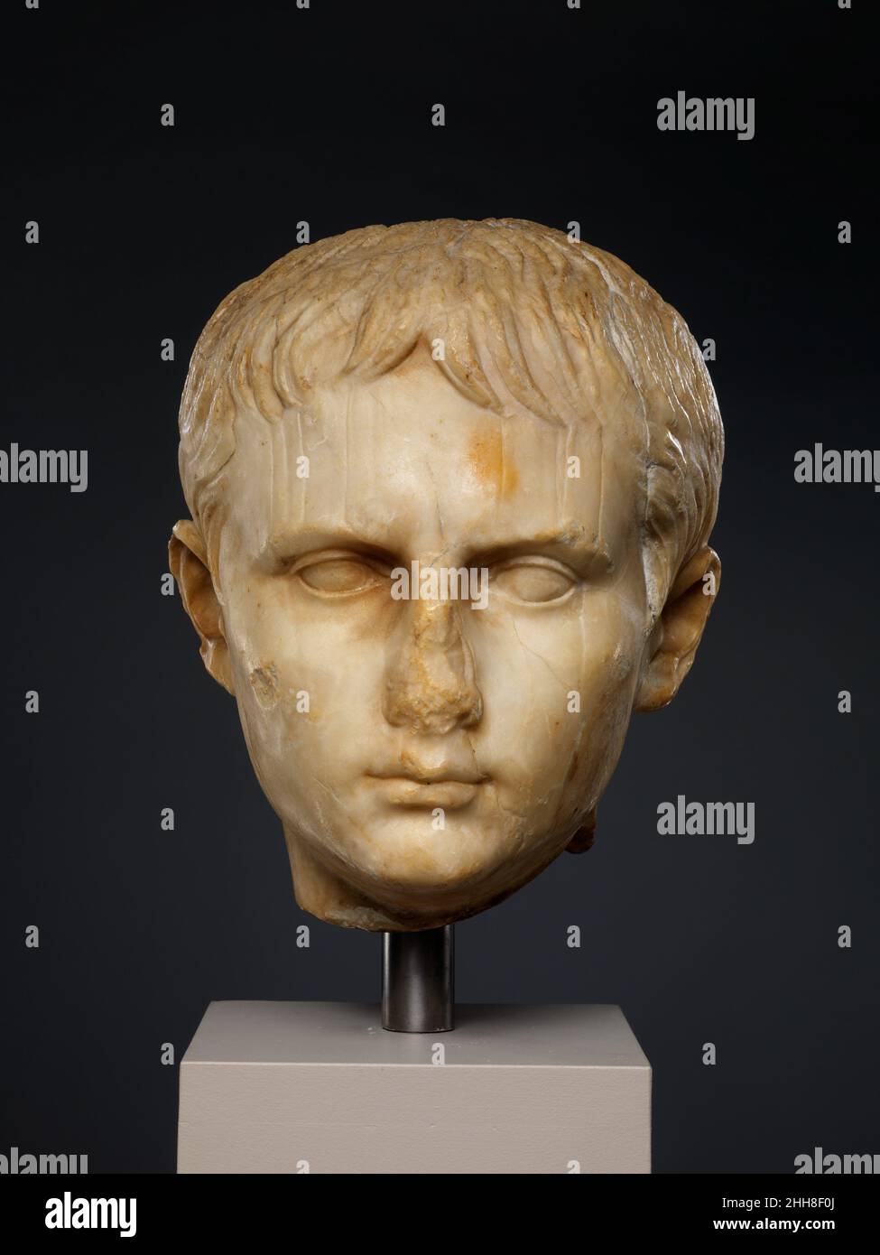 Testa di pietra di una giovinezza Giulio-claudiana, forse di Gaio Cesare ca. 5 a.C., o più tardi romana, la testa, tradizionalmente identificata come un giovane Augusto, può ora essere paragonata ai ritratti del suo nipote maggiore, Gaio Cesare (20 a.C.-d.C.) 4). Qui è rappresentato come un adolescente di circa 13 a 15 anni, datando così l'opera (se contemporanea) a ca. 7–5 a.C. tuttavia, l'identità e l'autenticità del capo attuale, come molti altri identificati come Gaius Cesare, rimangono oggetto di discussione e di ricerca accademica. La condizione della pietra contribuisce anche alla difficoltà Foto Stock