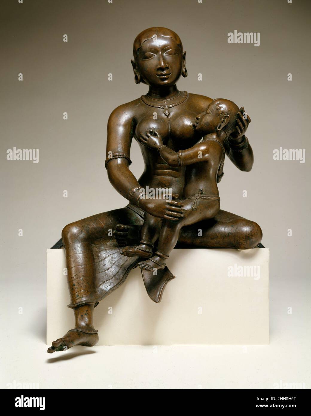 Yashoda con l'Infante Krishna all'inizio del 12th secolo India (distretti Tamil Nadu, PUDUKKOTTAI e Tanjavur) questa immagine tenera di affetto materno raffigura il bambino Krishna che viene nutrito da sua madre adottiva, Yashoda. Nell'infanzia Krishna era stato nascosto al re omicida Kamsa di Mathura per essere cresciuto in sicurezza dai genitori adottivi. Nel repertorio dei bronzi processionali dell'India del Sud gettati durante il periodo di Chola, questo soggetto è raramente rappresentato. La modellazione, la fusione e l'attrezzatura sofisticate collegano questo lavoro ai bronzi di Chola del tardo XI e XII secolo. Ascoltate gli esperti il Foto Stock