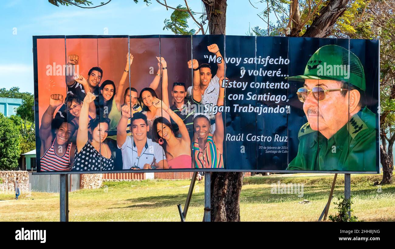 Billboard per strada con l'immagine di Raul Castro, una breve frase di sua, e un gruppo di cubani. Foto Stock