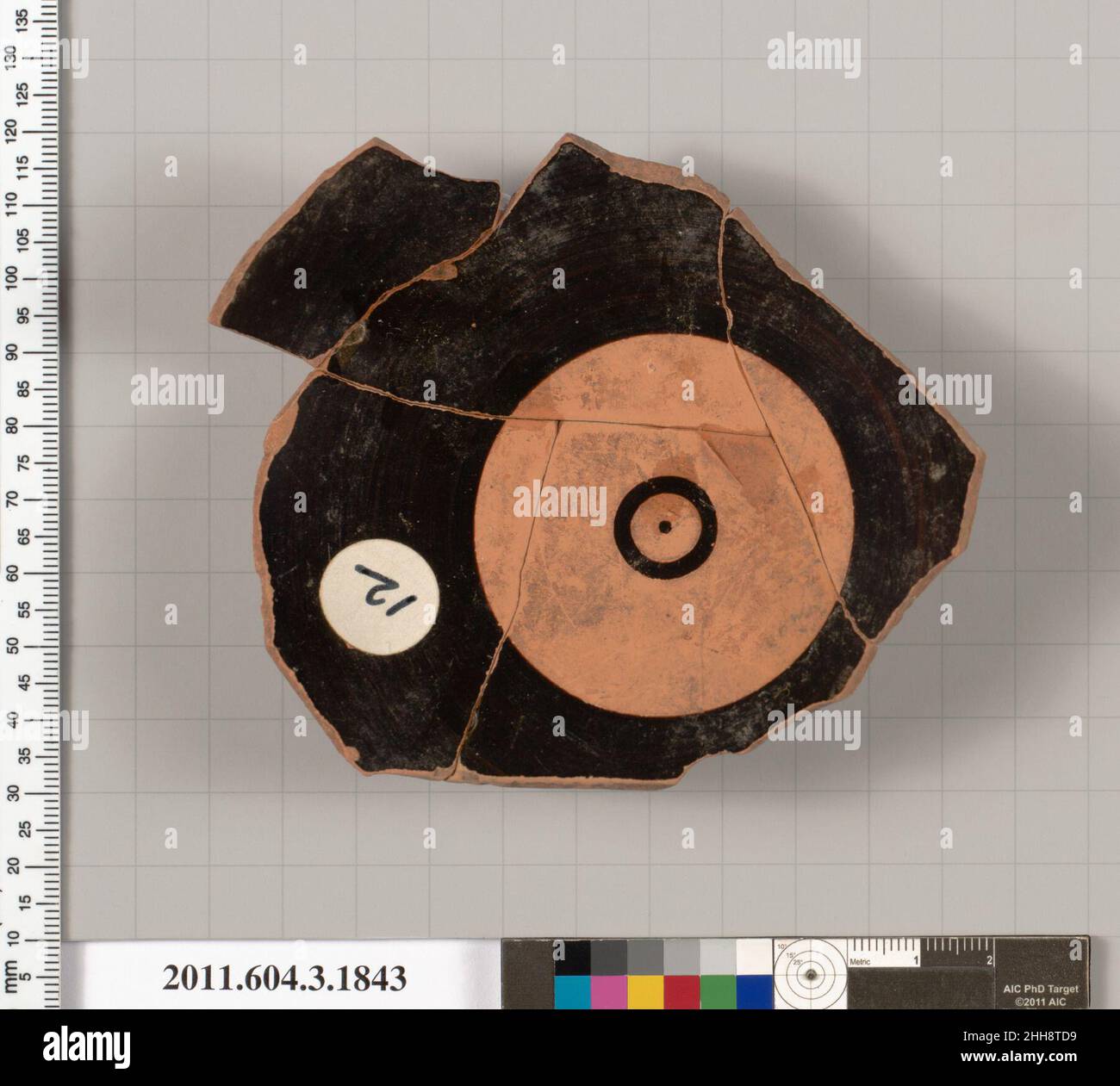 Frammento di terracotta di una kylix: Labbro Cup (tazza da bere) metà del 6th secolo a.C. Greco, Attico interno, tondo riservato con un piccolo cerchio smaltato nero al centro, che ha un punto al centro; esterno, un po 'di un tendine; sei lettere di un'iscrizione. Frammento di terracotta di una kylix: Tazza con labbro (tazza da bere). Greco, Attico. Metà 6th secolo a.C. Terracotta; figura nera. Arcaico. Vasi Foto Stock
