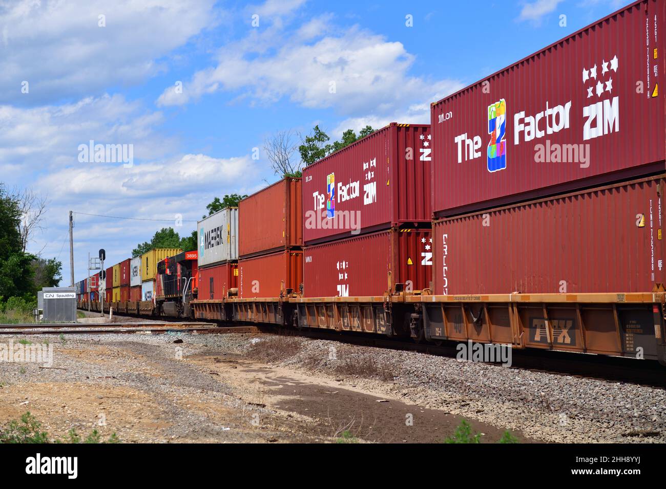 Bartlett, Illinois, Stati Uniti. Un treno merci intermodale ferroviario nazionale canadese con un'unità di potenza distribuita (DPU) si dirige attraverso un incrocio. Foto Stock