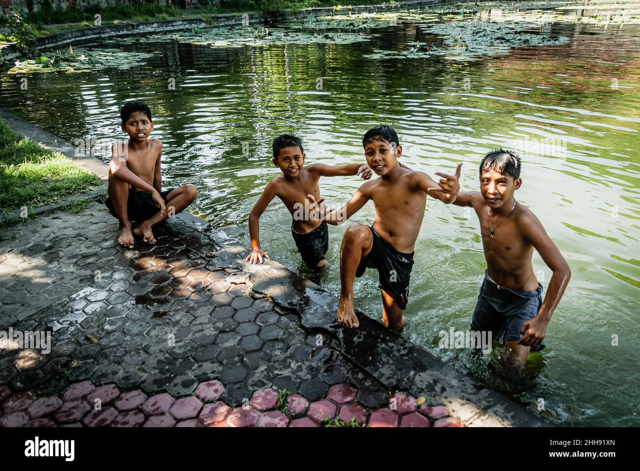 BALI, INDONESIA - 2 MARZO 2014: Bambini che posano allo stagno Foto Stock