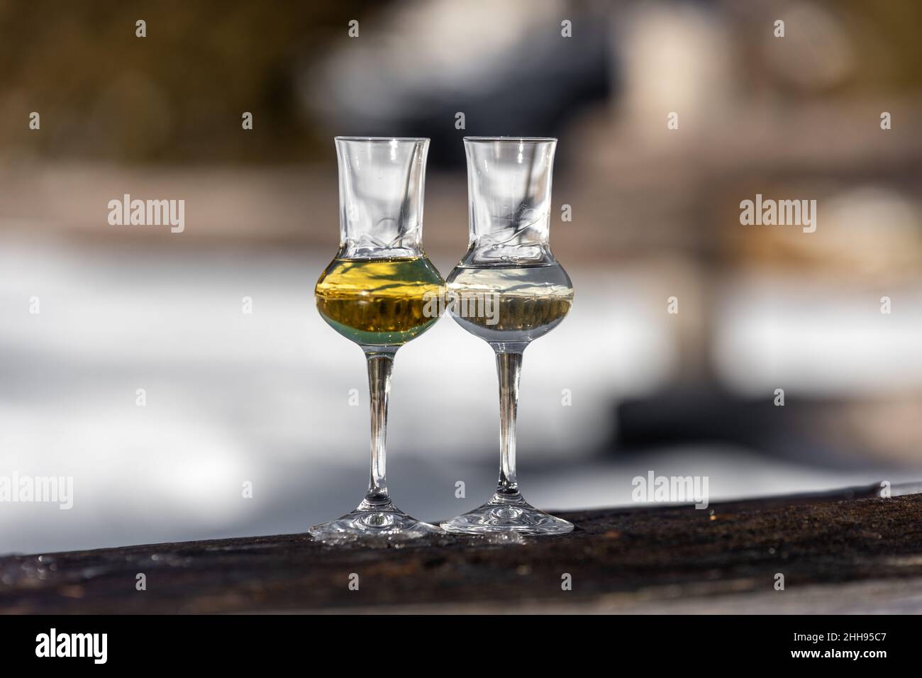 Bokeh foto di due bicchieri di Grappa aromatizzata (schnapps) a Cortina d'Ampezzo, Dolomiti, Italia Foto Stock