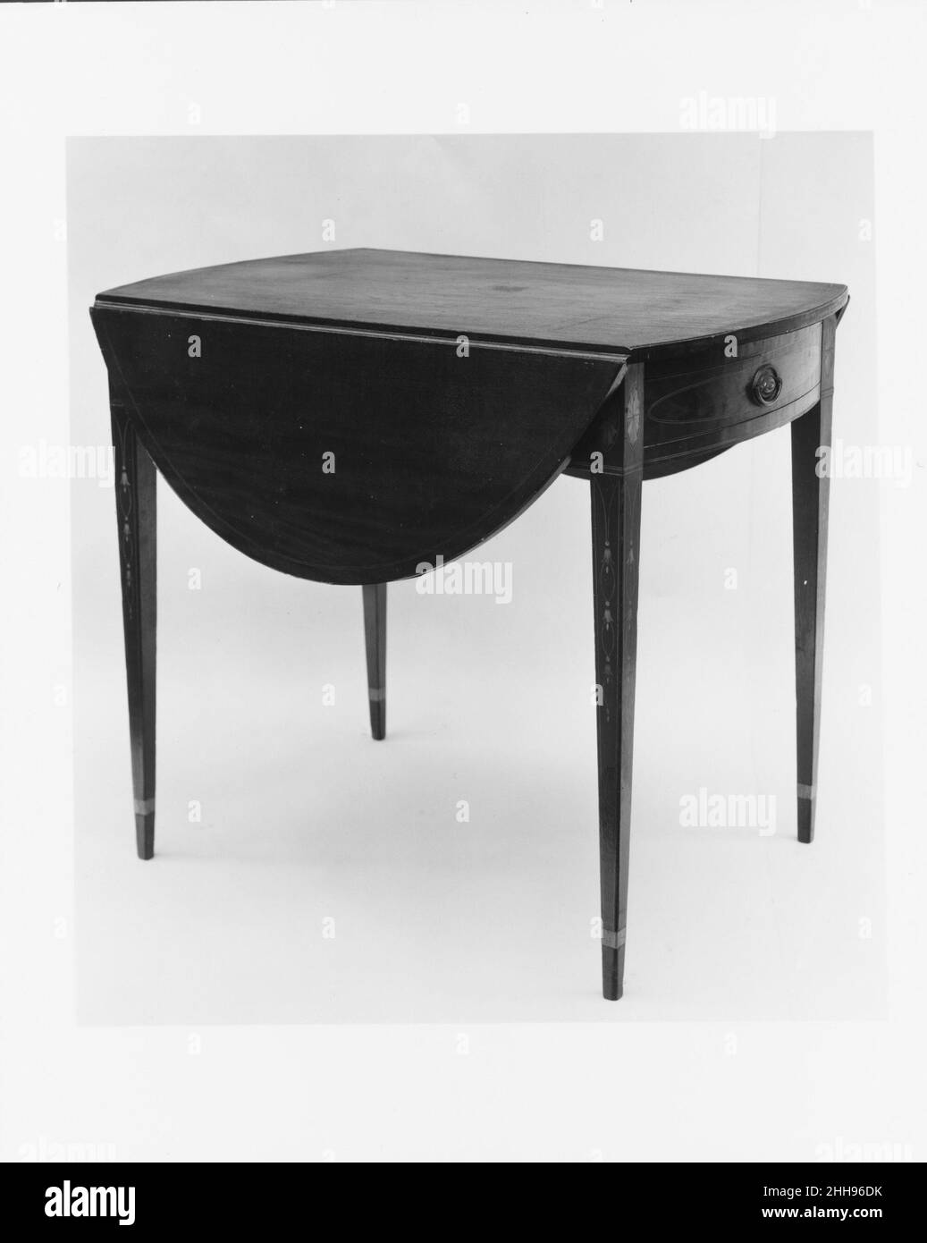 Tavolo Pembroke 1795–1805 americano questo piccolo tavolo presenta due foglie di goccia e un cassetto. Era ideale per pasti piccoli e informali o per prendere il tè. Nel suo “Cabinet Dictionary” (Londra, 1803), Thomas Sheraton descrive un tavolo Pembroke come “una sorta di tavolo per la colazione, dal nome della signora che ha dato per prima una di loro ordini, e che probabilmente ha dato la prima idea di tale tavolo ai lavoratori”. Tavolo Pembroke 5575 Foto Stock