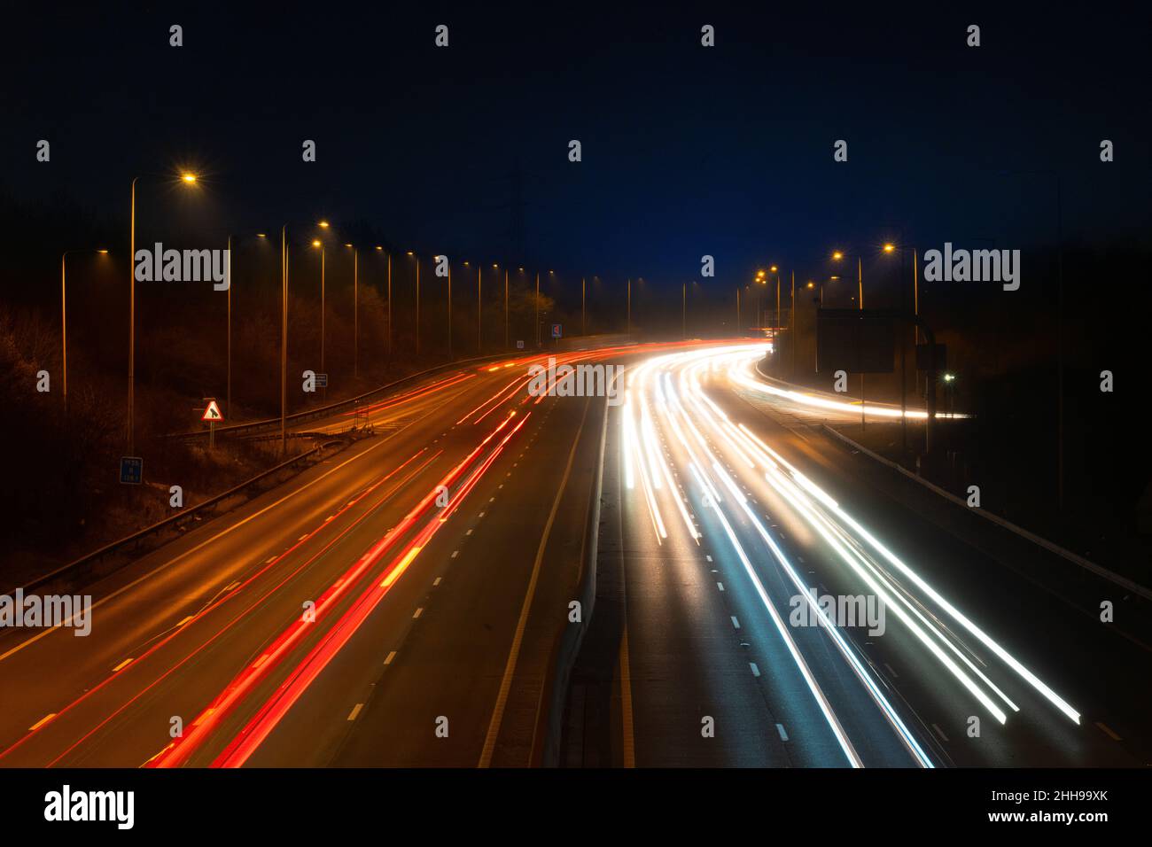 La M25 o London Orbital Motorway è una strada principale che circonda la maggior parte di Londra, di notte. Foto Stock