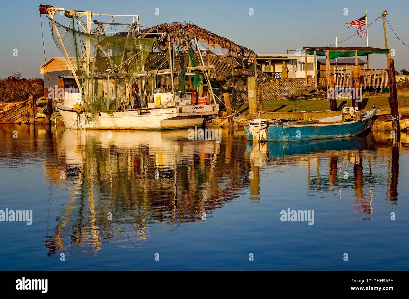 Al tramonto, 24 dicembre 2016, a Bayou la Batre, Alabama, sono raffigurati una barca per gamberetti e uno skiff di ostriche. La città è conosciuta come la capitale del pesce dell'Alabama. Foto Stock