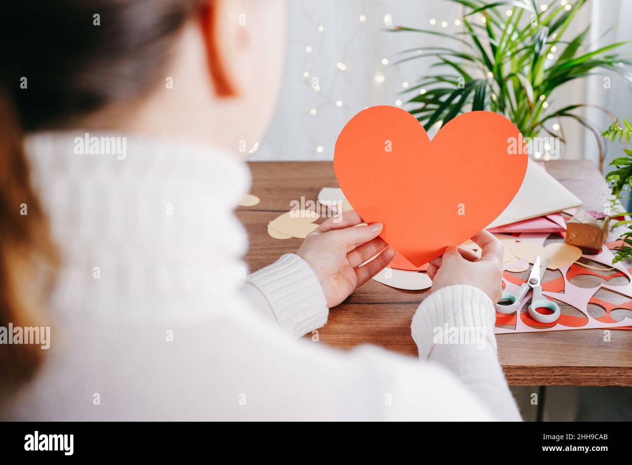 Donna mani che fanno di San Valentino biglietti d'auguri fatti a mano. Fai da te, regalo con le tue mani. Primo piano. Decorazione di San Valentino Foto Stock