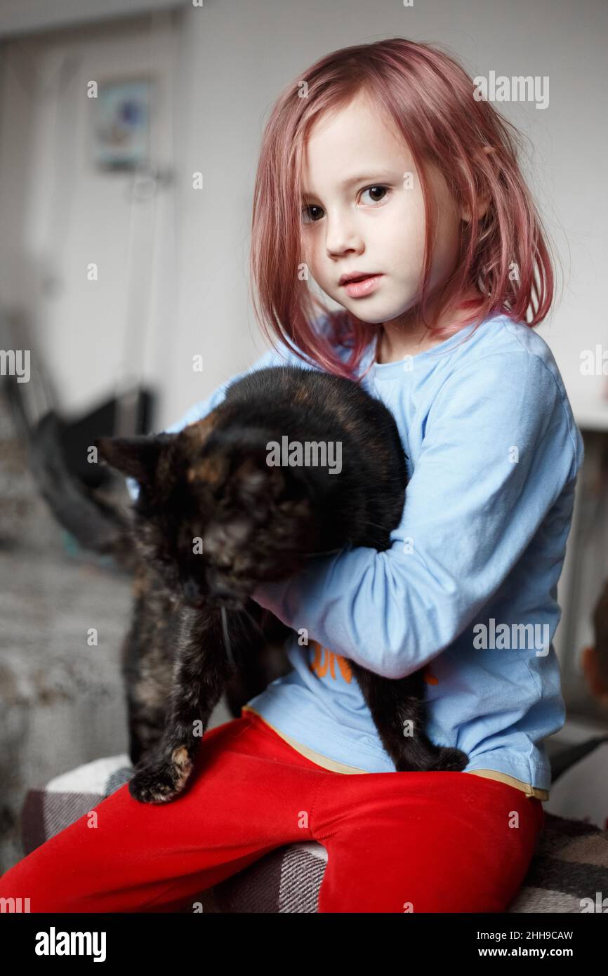 Ritratto di adorabile ragazza caucasica tenendo carino nero Cat.domestico animale domestico concept.lifestyle fotografia a casa Foto Stock