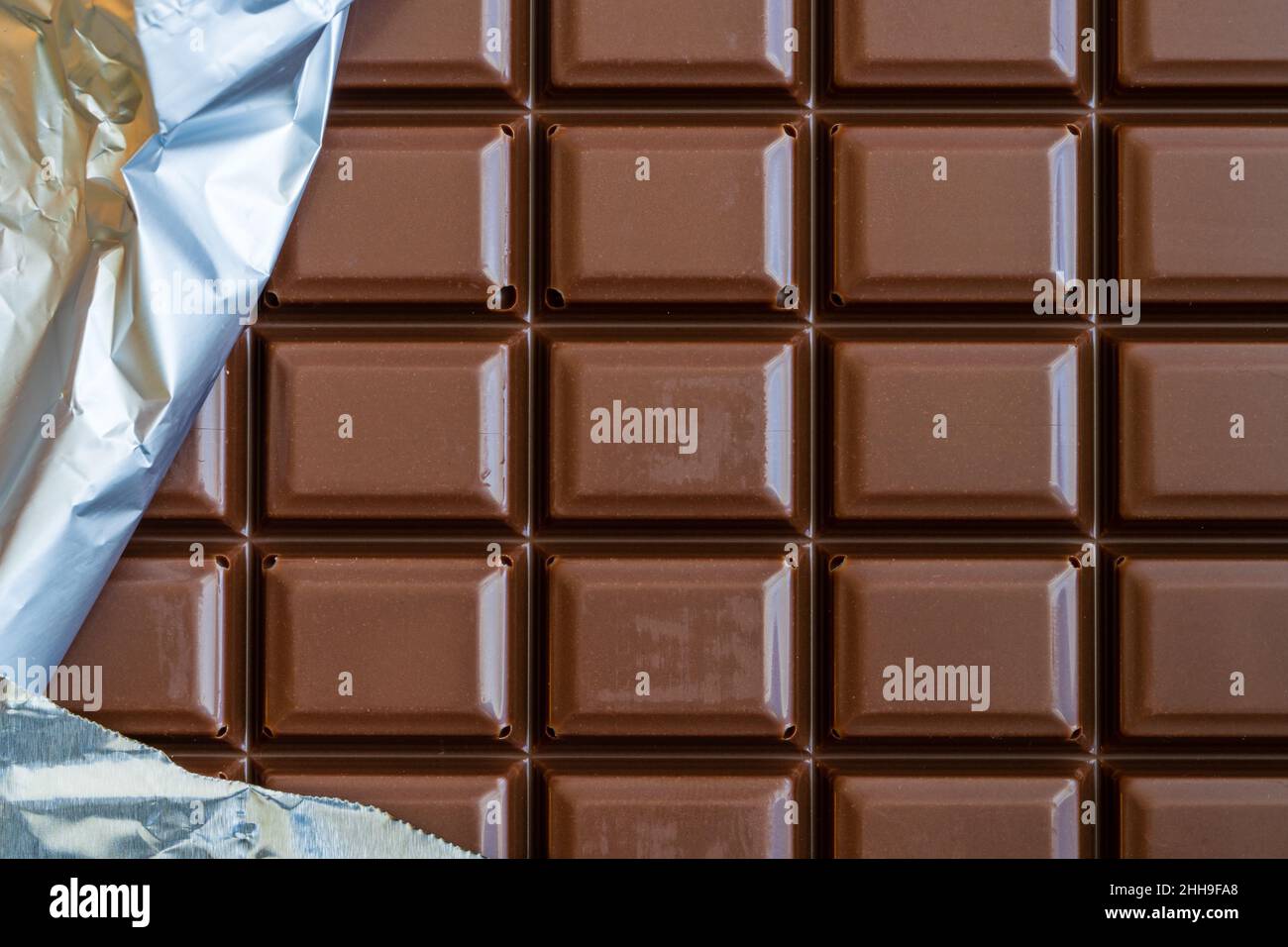 Barra di cioccolato con parte del wrapper argentato. Foto Stock