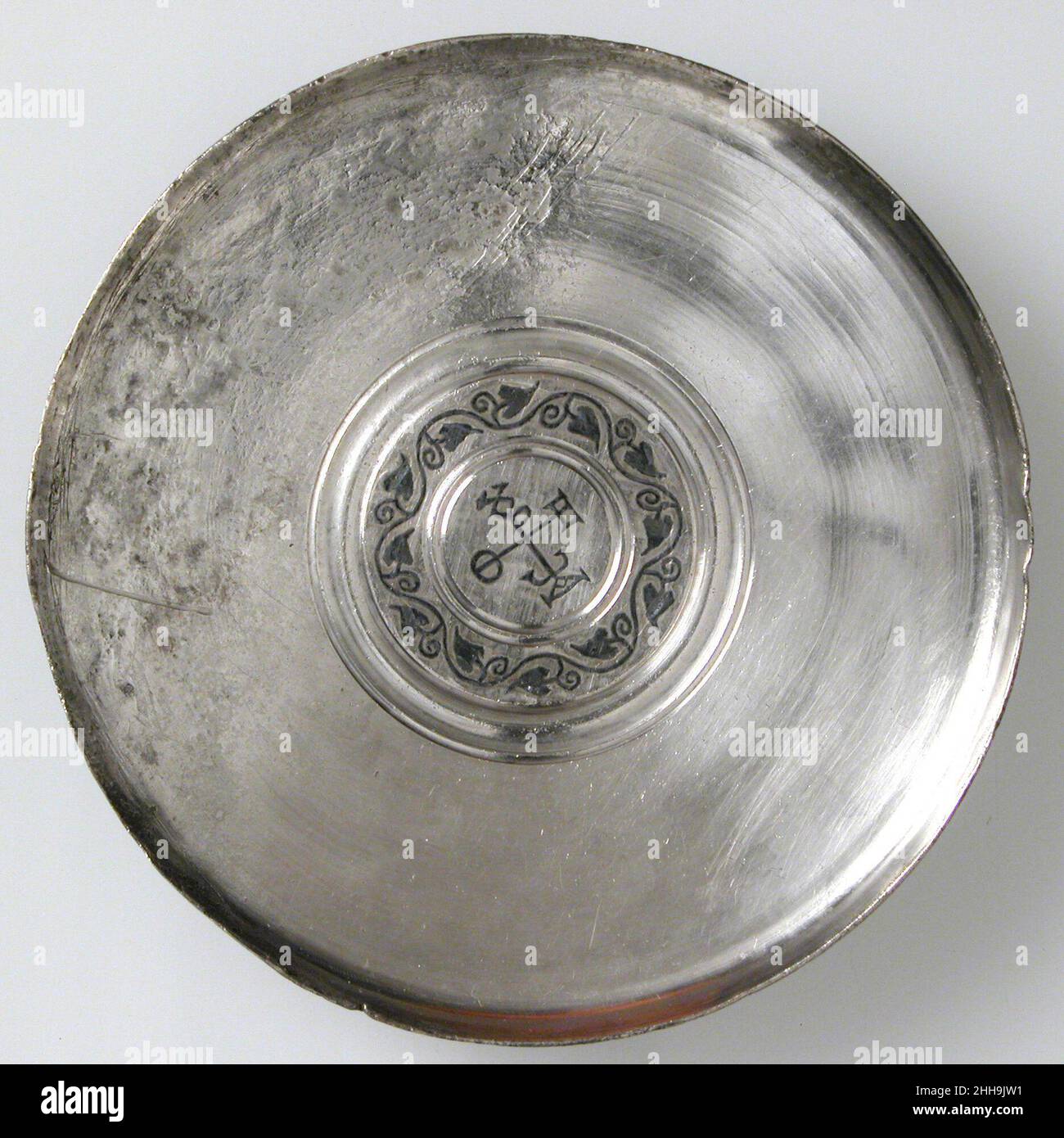 Piatto con monogramma 610–613 piatti bizantini come questo sono stati fatti in set per l'uso in case ricche. Le lettere greche alle estremità del monogramma a croce possono riferirsi al proprietario, Theodore A(?). I francobolli di controllo sul retro della targa lo risalgono all'inizio del regno dell'imperatore Eraclio (610–41). Piastra con monogramma 468387 Foto Stock