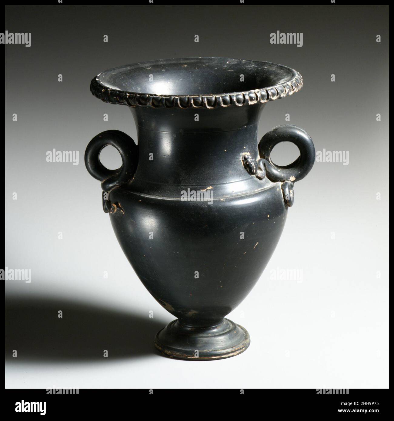 Terracotta krateriskos ca. 300 a.C. attribuite al Gruppo di Copenaghen 3817 le caratteristiche maniglie ad anello sono sotto forma di due serpenti le cui teste e code sono modellate con cura in rilievo. I serpenti erano spesso legati alla morte e alla rinascita nell'antico mondo mediterraneo. È noto che almeno un vaso di questo tipo specifico è stato utilizzato come urna di cremazione. Terracotta krateriskos (piccola conca di miscelazione) 255286 Foto Stock