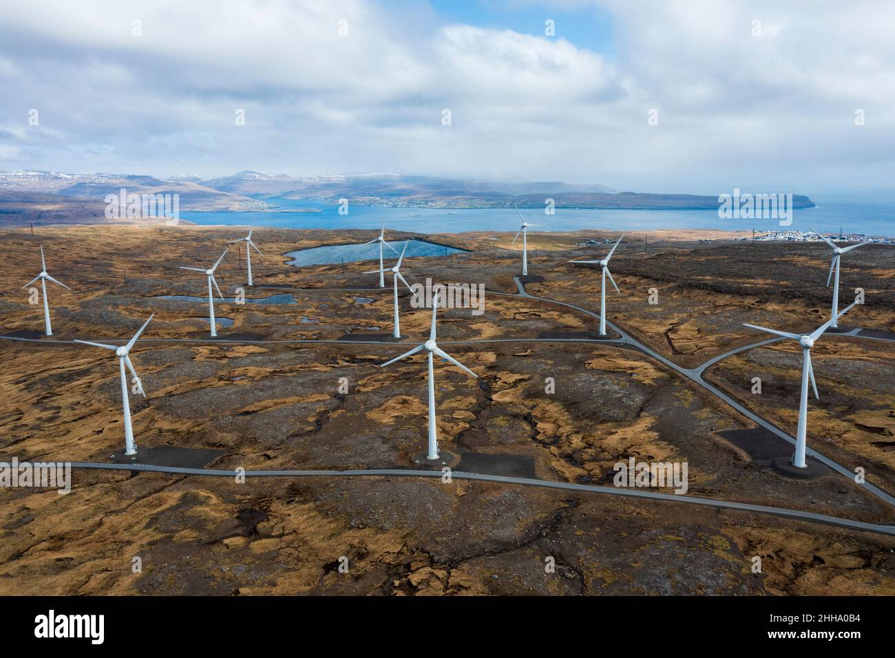 Le turbine eoliche non sono un blot su questo paesaggio aspro e senape colorato come sfruttano i feroci venti di Faroe Island. Foto Stock