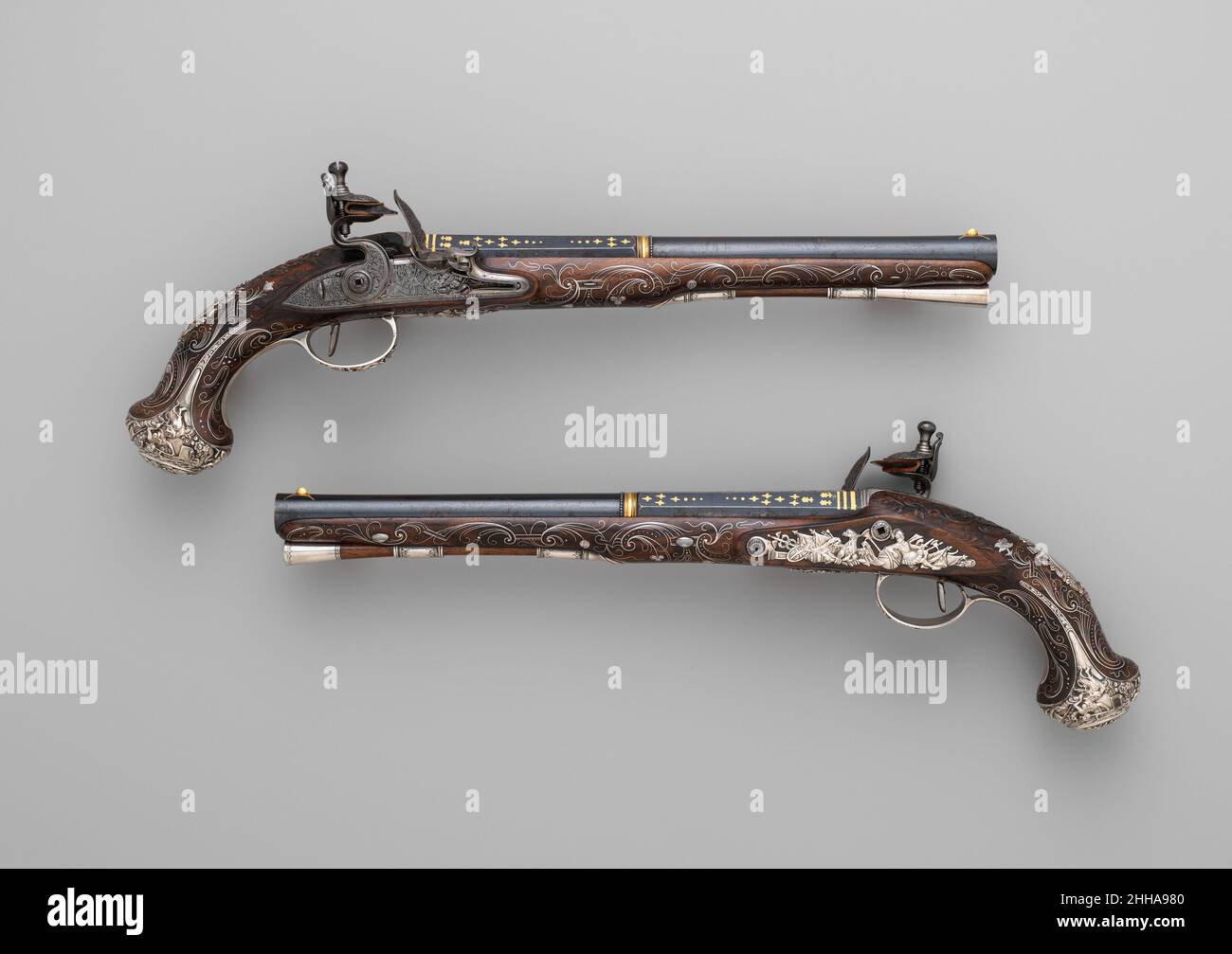 Coppia di pistole Flintlock ca. 1765 Henry Hadley questa coppia di pistole si colloca tra le armi da fuoco più raffinate ed elaborate fabbricate in Inghilterra nel terzo quarto del diciottesimo secolo. Si tratta di uno dei più grandi successi di Henry Hadley, che rappresenta una notevole unificazione di artigianato separato, tra cui incisione, scultura in legno, intarsio, argenteria, produzione di serratura, e barile forgiando. Hadley, un cannoniere londinese che si è dato servizio ai più alti eicoli della società britannica, compresa la famiglia reale, ha fatto le pistole per un membro della famiglia Clerk di Penicuik o della famiglia Clerk Foto Stock