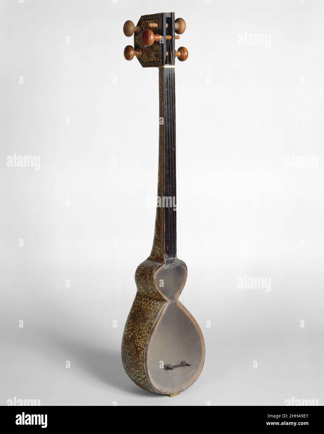 Tār (تار) fine del 19th secolo Iraniano (persiano) il tār apparve per la prima volta intorno a Shiraz e fu rapidamente adottato in Afghanistan e Caucasia dove fu modificato. tārs in stile iraniano hanno corpi con due aperture a forma di cuore disuguali che sono ricoperte da una sottile membrana di feto di agnello, un ponte di corno e tre doppi corsi di corde. La pancia della pelle è molto sensibile al tocco del giocatore e quindi richiede un alto grado di virtuosità quando viene afflosciata con un plectrum di ottone. Oltre a liuti come il ūd, con grandi, dorsi a volta, Bellies di legno, e relativamente corti, Colli non grottiti, il Medio Oriente poss Foto Stock