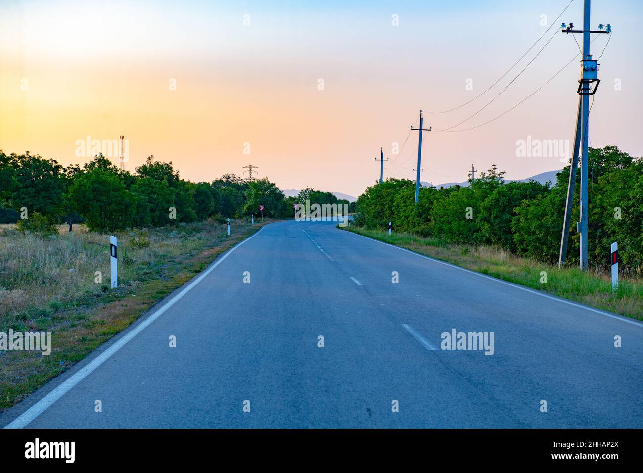 al tramonto una strada asfaltata va verso le montagne Foto Stock