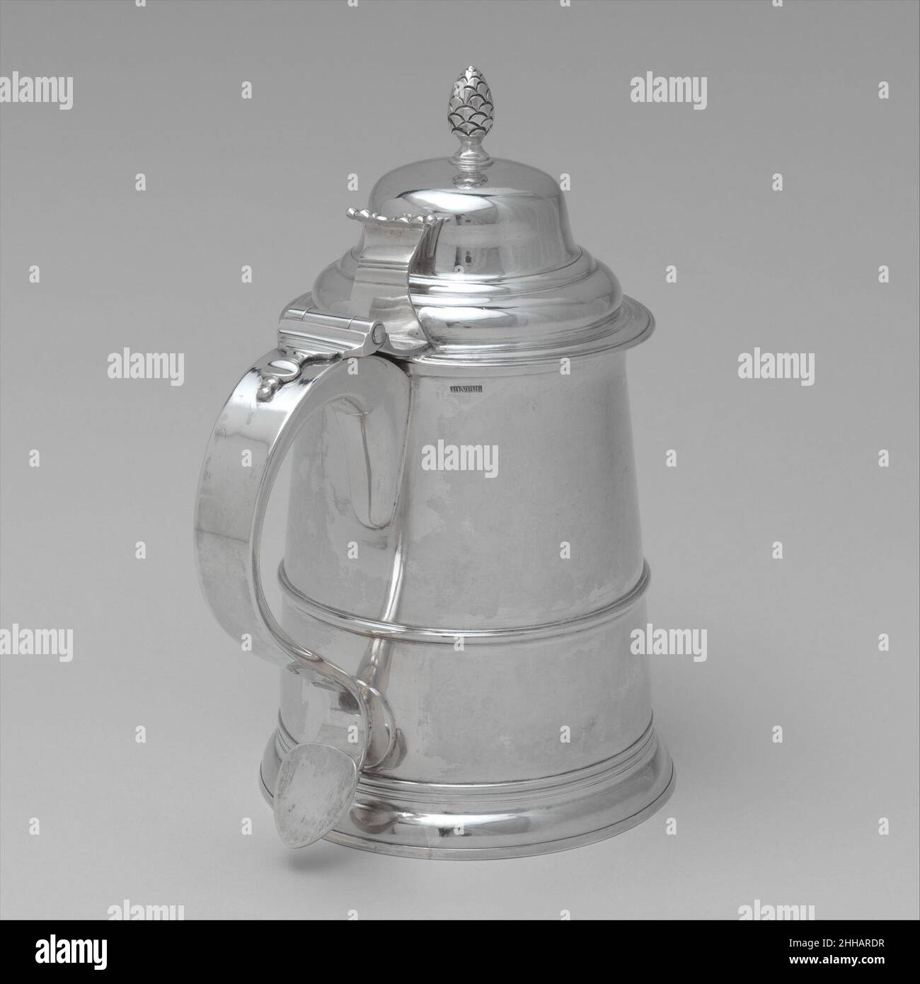 Tankard ca. 1795 Paul Revere Jr. American Mid-XVIII secolo i tankard di Boston tendevano ad essere alti e rastremati, con coperture a cupola e midband orizzontali. Alla fine del secolo, quando il vogue per questi vasi da bere aveva cominciato a svanire, crebbero ancora più alti, con una cupola più esagerata alla copertura. Questo è particolarmente grande. Il monogramma e B' inciso sul suo fronte sta per Samuel e Elizabeth Bradley, sposati il 2 settembre 1784. Appare nel libro del conto di Paul Revere per l'anno 1795, dove elenca un tankard di tre pinte sotto il nome di Bradley. Tankard 821 Foto Stock