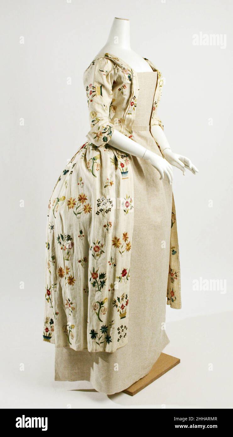 Accappatoio à l'Anglaise 1725–50 gli abiti inglesi in lino, versioni semplici di abbigliamento contemporaneo, erano popolari tra le donne gentili per l'abbigliamento mattutino nella campagna inglese. Questi camici erano molto sensati, in quanto potevano essere riciclati spesso e mantenere ancora un aspetto fresco. Erano spesso decorate con ricami, solitamente cuciti dalla stessa indossatrice. Il ricamo era considerato un'occupazione delicata e femminile per le donne di tutte le classi della società. Il vivace ricamo floreale in questo abito da giorno è stato probabilmente fatto da un modello già fatto, anche se il ricamo ha individualizzato i bouquet floreali. Rob Foto Stock