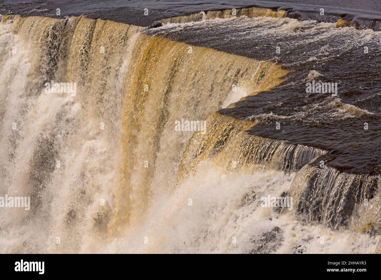 Acque scure che precipitano sul Brink sulle cascate di Kakabeka in Ontario, Canada Foto Stock