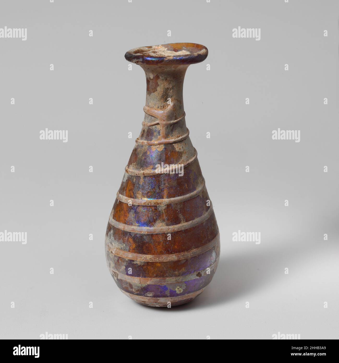 Bottiglia di profumo di vetro 2nd metà del 1st secolo d.C. romana traslucido giallo ambrato, con trail.Rim bianco opaco piegato fuori, sopra e dentro; bocca svasata; corto, Snello collo cilindrico, che si espande alla base per unirsi impercettibilmente con corpo piriforme allungato; fondo convesso ma leggermente appiattito.traccia singola applicata in grande platorello alla base del collo e disegnata a spirale in nove giri, terminando sul fondo; La metà superiore del sentiero è in rilievo, il resto è marvered in body.intact; pinprick bolle, cremoso tempo e iridescence, con un po 'di vaiolatura. Bottiglia di profumo in vetro 239734 Foto Stock