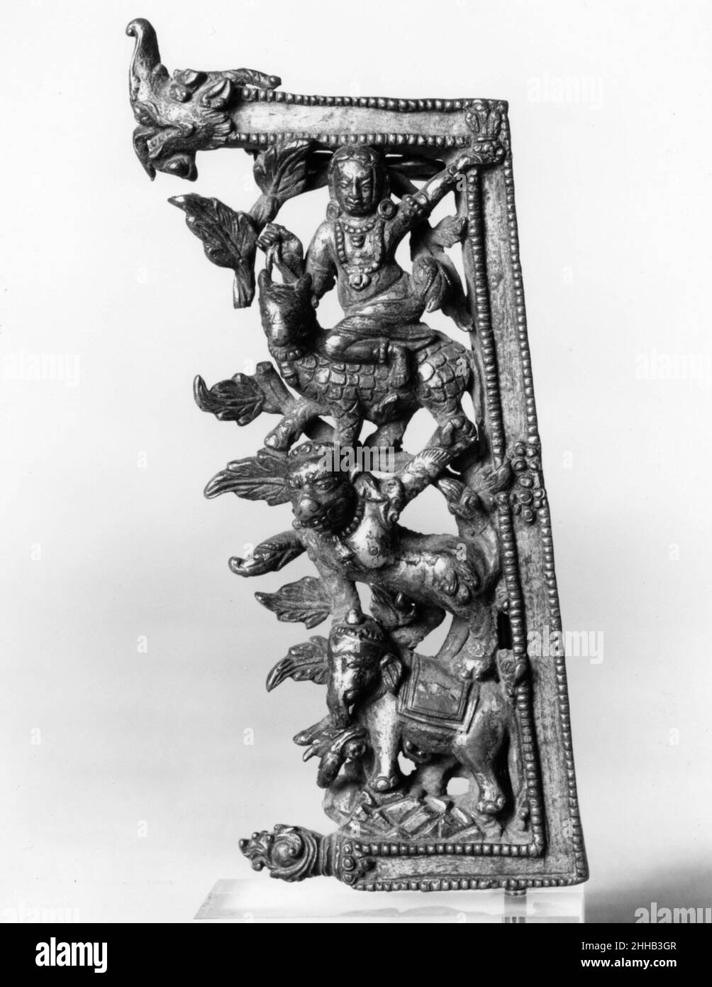 Frammento dal backplate di un'icona 16th secolo Nepal (valle di Kathmandu) questo pannello di apertura raffigura un mélange di fantastici animali riotamente messi in fogliame, uno sull'altro: un elefante su una montagna rocciosa, un leone in piedi sulla schiena, sopra una creatura simile a rinoceronte con testa di toro, cavalcata da un demigodo. La cornice a falde con perline ha come terminale una makara, una creatura marina fantastica. Frammento dal backplate di un'icona 38346 Foto Stock