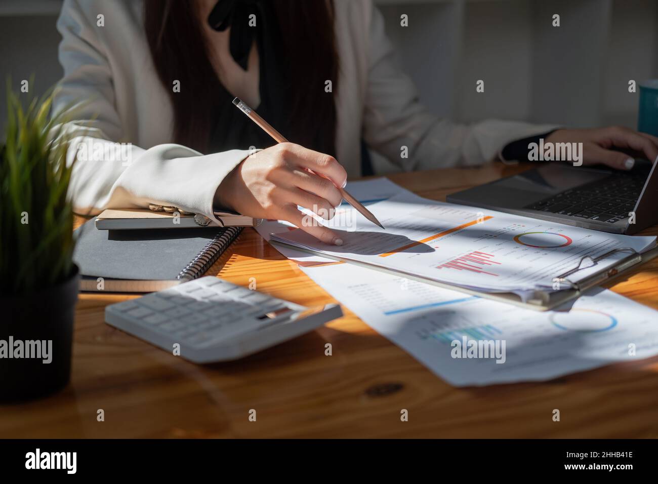 Financial Businesswoman analizza il grafico delle prestazioni dell'azienda per creare profitti e crescita, rapporti di ricerca di mercato e statistiche sul reddito Foto Stock