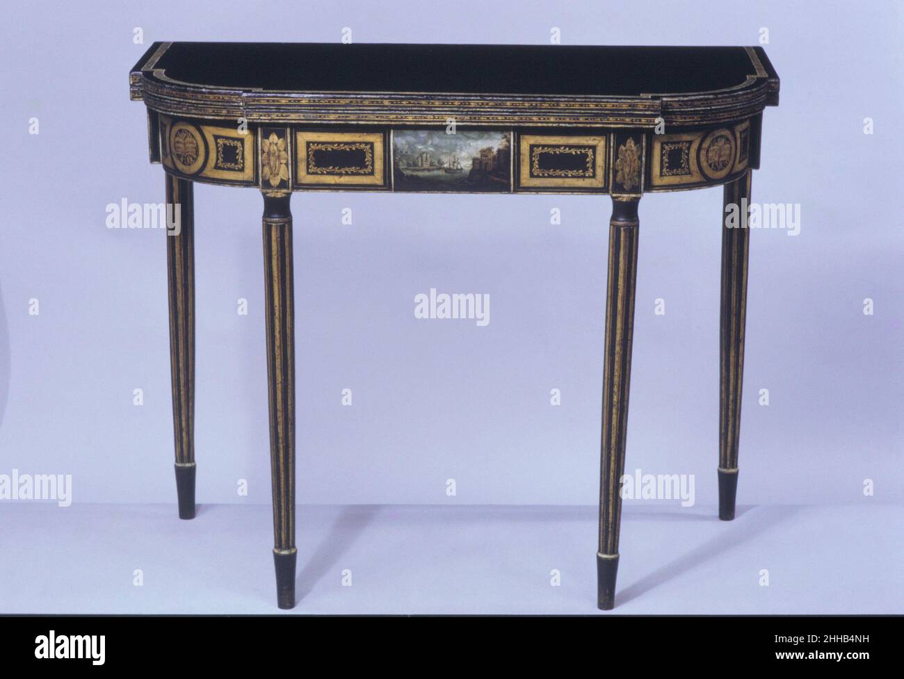 Card Table 1800–1810 attribuito a John Finlay Una tabella con decorazione quasi identica è stata inclusa in un insieme documentato fatto dai Finlay nel 1805 per John Morris (1785–1874) di Baltimora. La scena portuale dipinta è attribuita a Francesco Guy sulla base della sua somiglianza ad altri esempi della sua opera. Guy lavorò per i Finlay dal 1804 al 1810.. Tabella delle schede 1439 Foto Stock