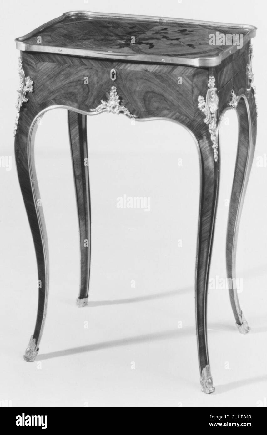 Tavolo da lavoro e scrittura ca. 1755–60 Bernard II van Risenburgh questo piccolo tavolo da lavoro e da scrittura di Bernard II van Risenburgh è realizzato in rovere impiallacciato con tulipwood e kingwood tagliato in testa e montato in bronzo dorato. La parte superiore incernierata si apre per rivelare una rientranza suddivisa in tre sezioni. Un cassetto separato si apre sul lato destro del tavolo, che contiene uno scomparto stretto con un getto d'inchiostro in metallo argentato, un canale per una spugna, e una scatola per sabbia per eliminare l'inchiostro in eccesso. Anche se non quasi così ornati come gli armadi ad angolo laccati in stile asiatico prodotti da van Risenburgh nel museo” Foto Stock