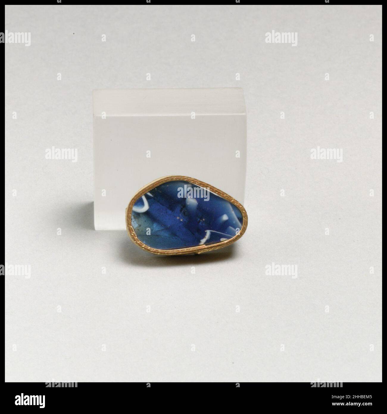 Mosaico di vetro con bacchette a coste frammento fine 1st secolo a.C.–inizio 1st secolo d.C. corpo romano frammento.traslucido blu e opaco bianco.curvo poco profondo lato.motivo Mosaico in una terra blu con motivo indeterminato di bacchette bianche e cerchi; parte di una costola poco profonda con bordo esterno arrotondato su esterno.interno lucidato; Molto poco vaiolatura su interno; dulling e cremoso iridescente agenti atmosferici su esterno e bedges.possibilmente dallo stesso vaso di 91,1.1973.. Mosaico di vetro dentellato frammento di ciotola 257171 Foto Stock