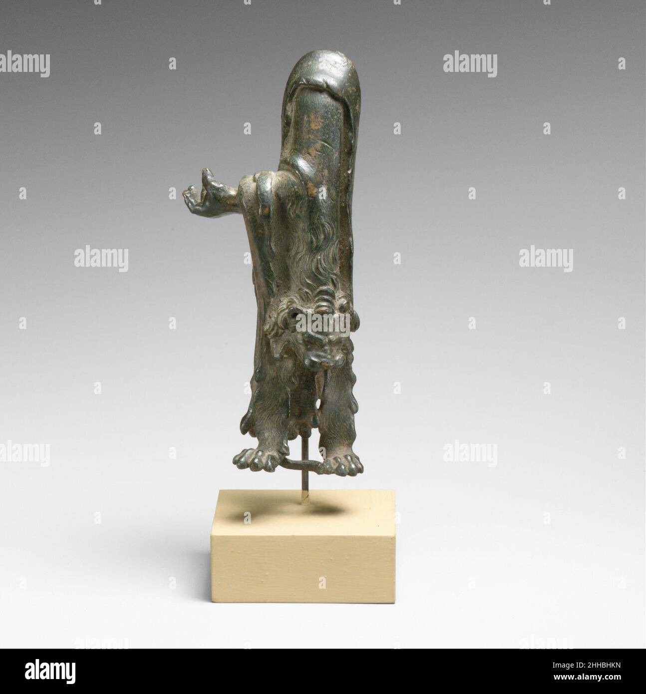 Statuette di bronzo frammentaria di Herakles con pelle di leone 1st–3rd secolo d.C. romana la pelle di leone finemente intagliata trascinata sul braccio di questa figura lo identifica come Herakles. Nella sua mano sinistra, può avere una volta tenuto mele, un attributo comune di statue di bronzo del tipo. Dopo che Herakles uccise il leone Nemean e lo skinned usando i relativi propri artigli, l'eroe indossava costantemente la pelle del leone sopra la sua spalla. Statuetta di bronzo frammentaria di Herakles con pelle di leone 252928 statuetta di bronzo frammentaria romana di Herakles con pelle di leone, 1st?3rd secolo d.C., Bronzo, H. 5 3/4 in. (14,6 cm. Foto Stock