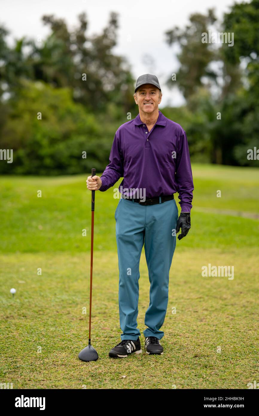 Bel golf pro sorridendo alla macchina fotografica e al randello holding Foto Stock