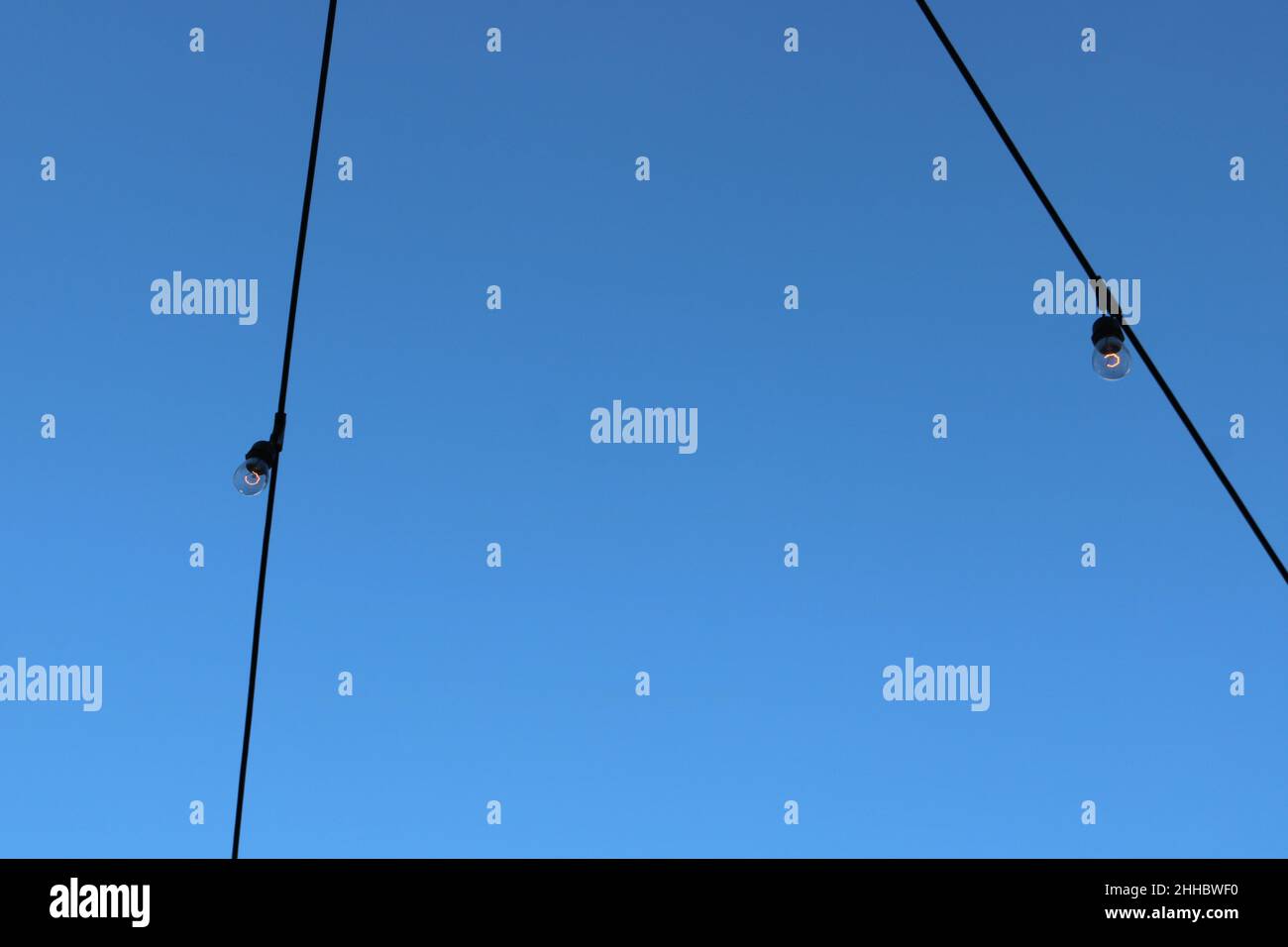 Lampadine contro il cielo. Concetto di creatività. Idee, linea di pensiero. Sfondo blu. Foto Stock