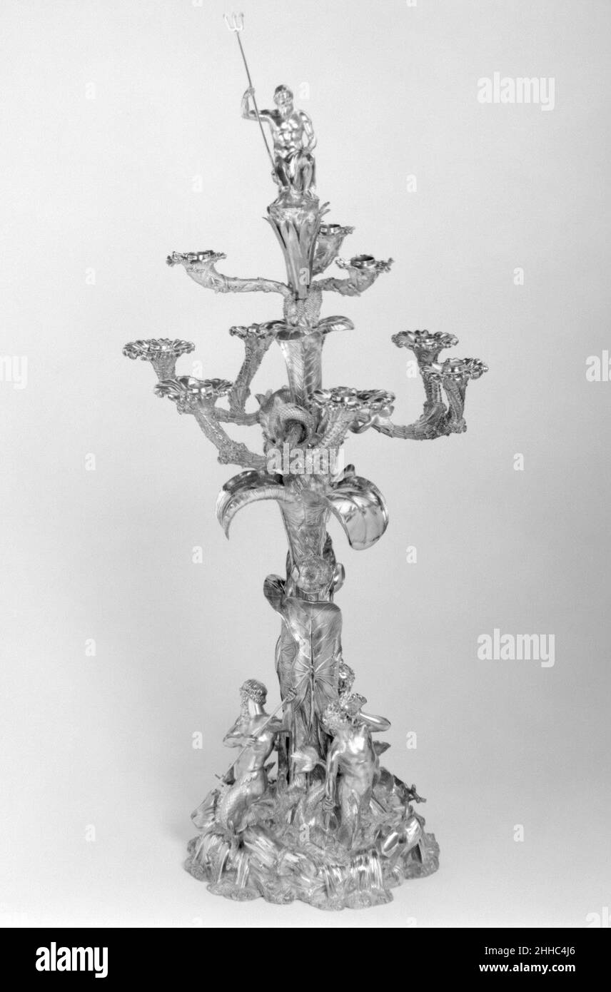 Candelabro a nove luci 1838–39 Paul Storr British questo imponente centrotavola destinata al centro di un tavolo ha due livelli per candele, la tomaia a tre braccia, la parte inferiore a tre braccia doppie, creando nove luci complessive. La luce della candela serviva a enfatizzare la figura di Poseidone, il dio greco del mare noto ai Romani come Nettuno. Egli siede in mezzo a canne alte. Il tema dell'oceano-Poseidone è continuato nelle alghe e nel corallo che avvolgono le braccia della candela e dalle figure intorno alla base: Un tritone che soffia una conchiglia con cui calma le acque, e un nereid, entrambi con corpi che si dividono Foto Stock