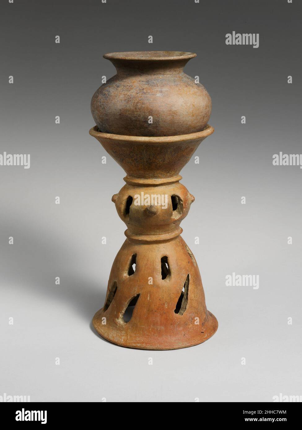 Terracotta holmos (stand) fine 8th-inizio 7th secolo a.C. Etrusca Una piccola versione di un tipo popolare di banchetto nave utilizzato per mescolare vino e acqua e poi servire gli ospiti. Gli holmos hanno due file di perforazioni sulla base. Le perforazioni ovoidi si alternano a grandi borchie sulla sezione intermedia sferica. Il piano svasato piano sostiene un dinos non decorato. Holmos in terracotta (stand) 246645 Foto Stock