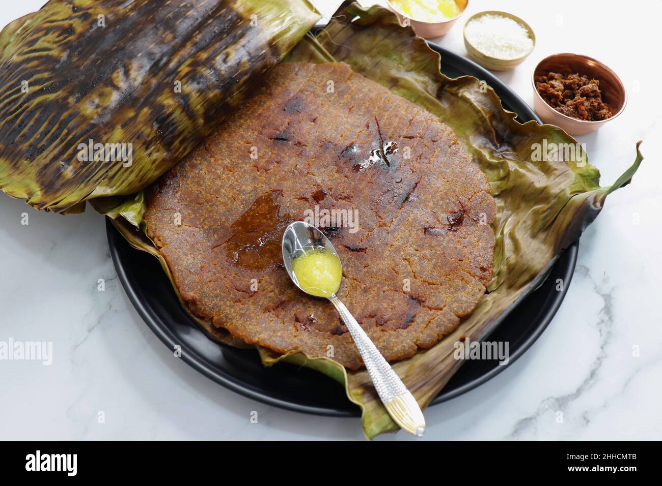 Roti dolci a base di farina di riso, gelate e ghee. gur ki roti. gur ki roti, bhakri gelatinoso, roti meethi gud ki cotto in foglia di banana. Cibo invernale Foto Stock