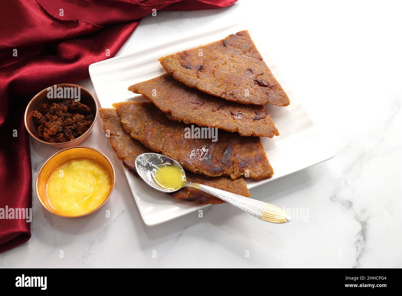 Roti dolci a base di farina di riso, gelate e ghee. gur ki roti. gur ki roti, bhakri gelatinoso, roti meethi gud ki cotto in foglia di banana. Cibo invernale Foto Stock