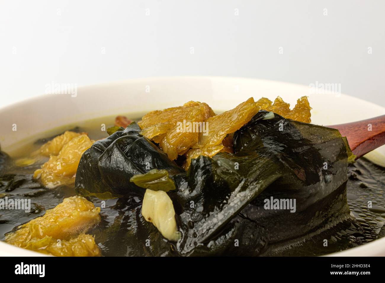 Zuppa gialla di alghe pollacche su sfondo bianco Foto Stock