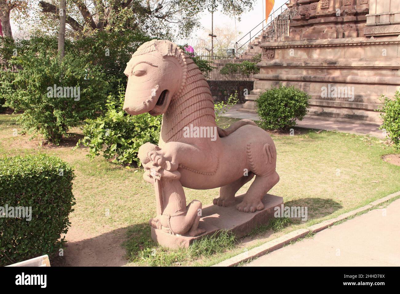 Antica statua di pietra di un re combattente e un leone vicino al tempio di Khajuraho, Madya Pradesh, India. Sito patrimonio dell'umanità dell'UNESCO Foto Stock