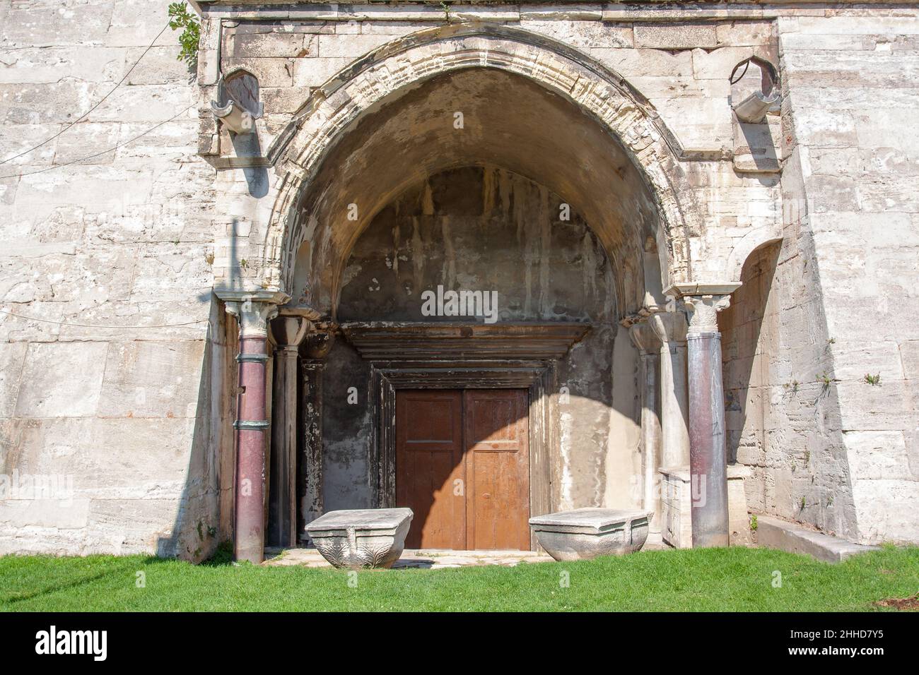 Antico ingresso ad arco con colonne in una spessa fortezza medievale. Foto Stock