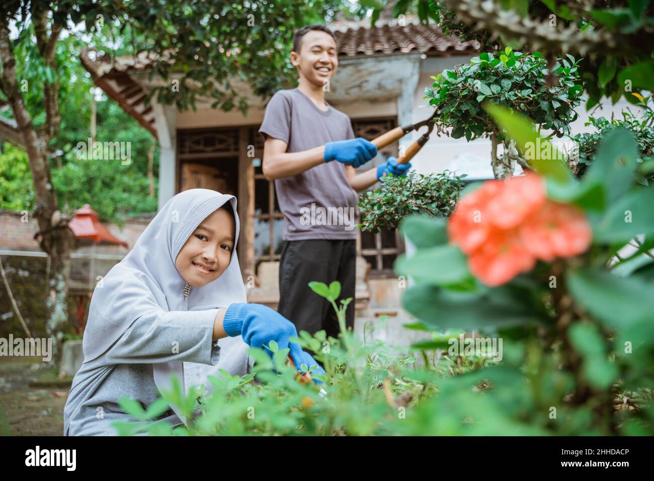 Sorridendo ragazzo e ragazza usando forbici di pianta per tagliare le foglie Foto Stock