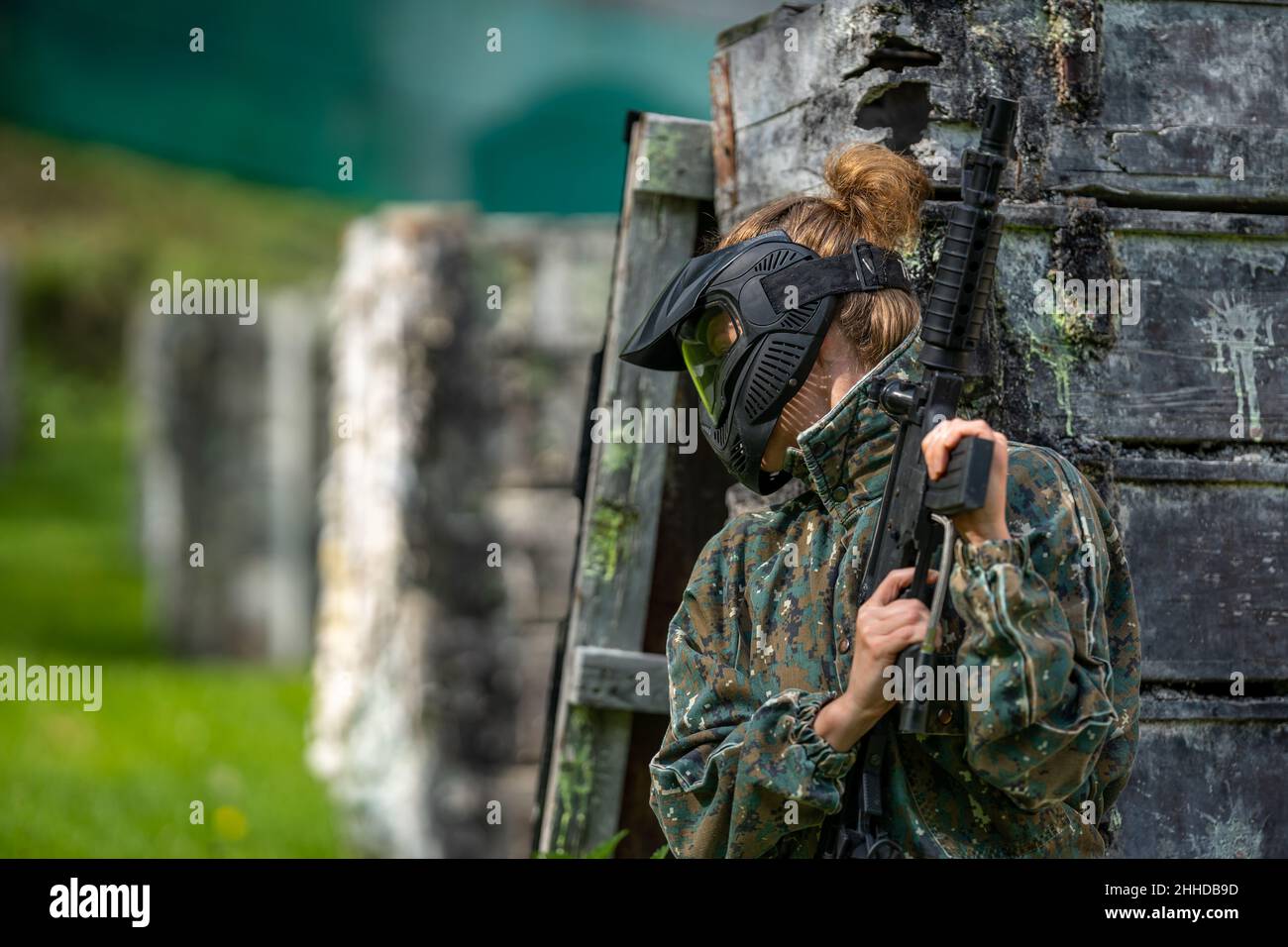 giovane donna in azione mentre si gioca paintball Foto Stock