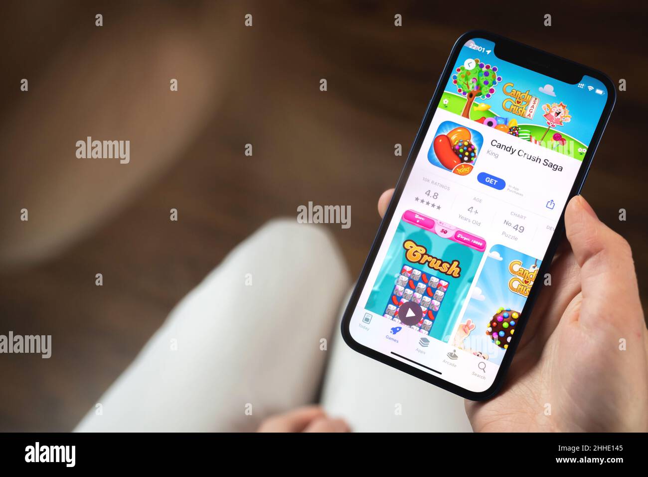 Kharkov, Ucraina - 19 gennaio 2022: Applicazione di gioco Candy Crush Saga. Ragazza che tiene il telefono cellulare con gioco e vuole giocare. Il concetto popolare di giochi per dispositivi mobili Foto Stock