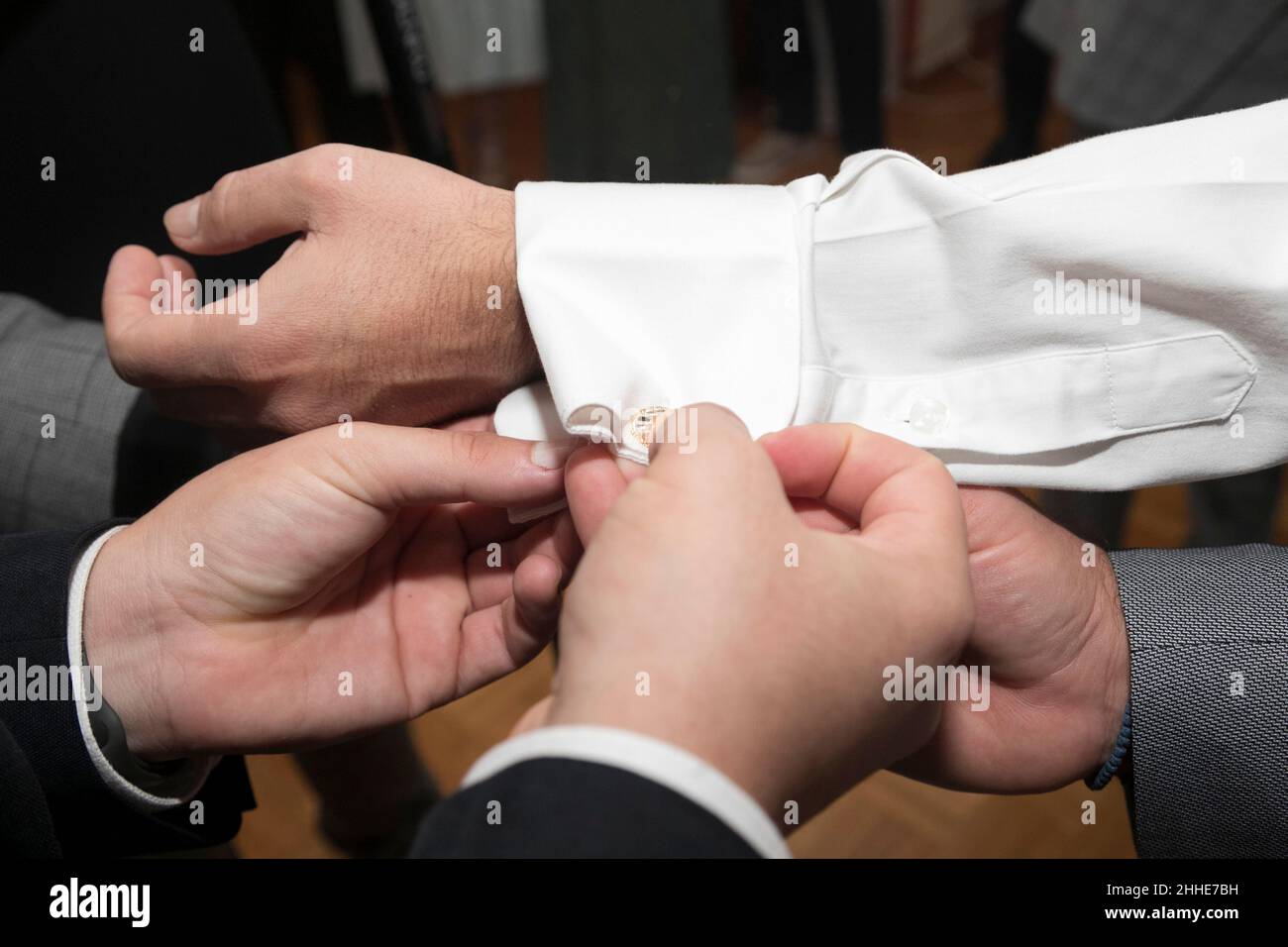 Primo piano del braccio dello sposo vestito dai suoi migliori amici. Messa a fuoco soft Foto Stock