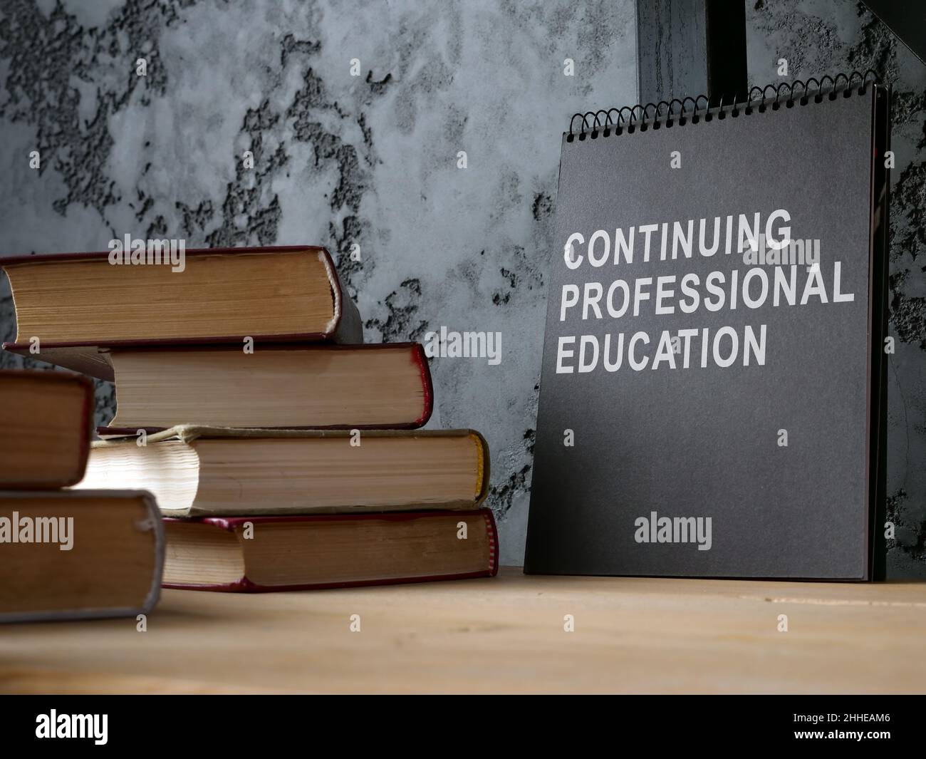 Formazione professionale continua sul blocco note nero e libri. Foto Stock