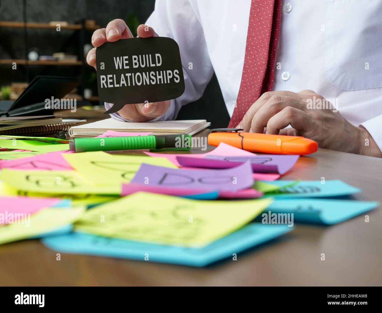 Un manager mostra il segno che costruiamo relazioni. Foto Stock