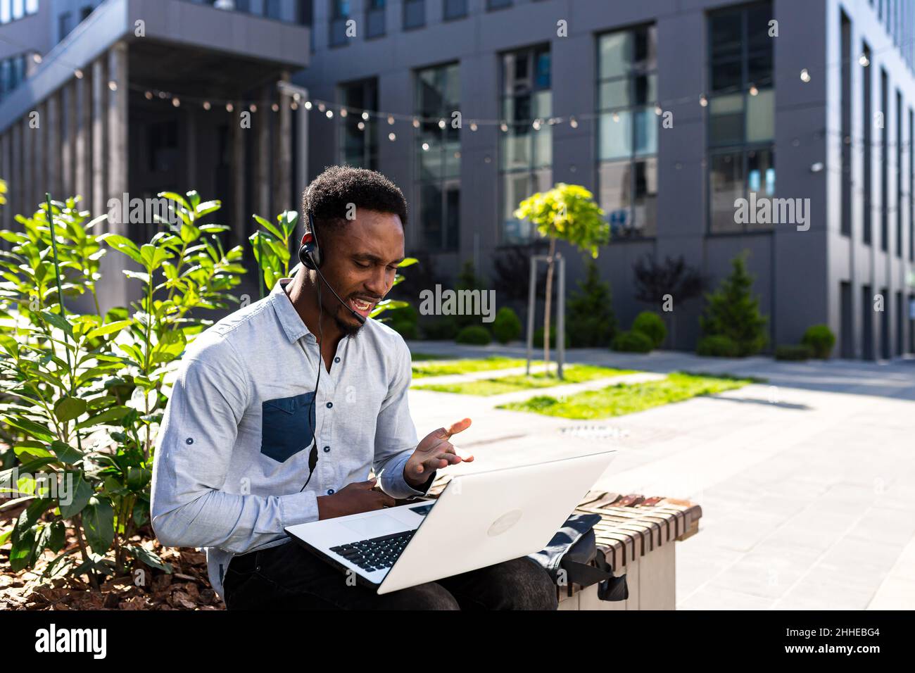 Arrabbiato, irato africano americano maschio freelancer lavoro litigare in remoto online con cuffie e laptop. Videochiamata conferenza o distanze meetin Foto Stock