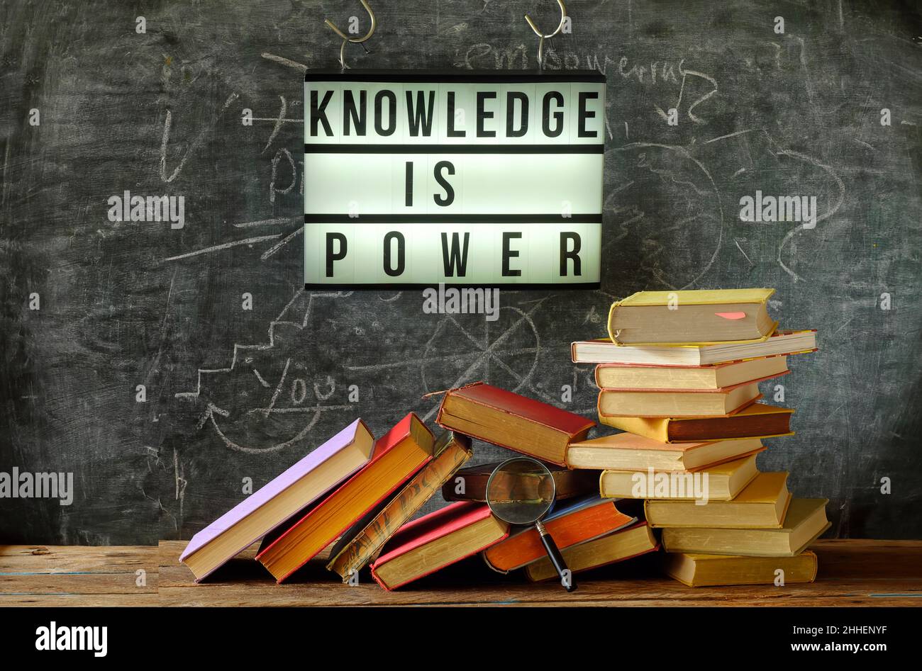 la conoscenza è potere, istruzione, apprendimento, concetto di ritorno alla scuola, segno, mucchio di libri e vetro mgnifying Foto Stock