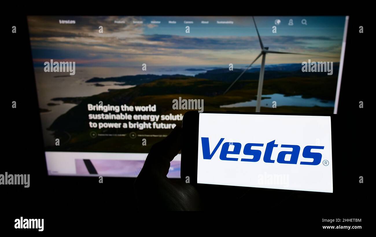 Persona che tiene uno smartphone con il logo della società danese Vestas Wind Systems SULLO schermo davanti al sito Web. Mettere a fuoco sul display del telefono. Foto Stock