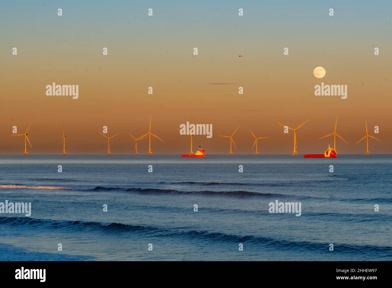 Wolf Moon e tramonto su Aberdeen Offshore Windfarm, Aberdeen, Scozia, Regno Unito Foto Stock