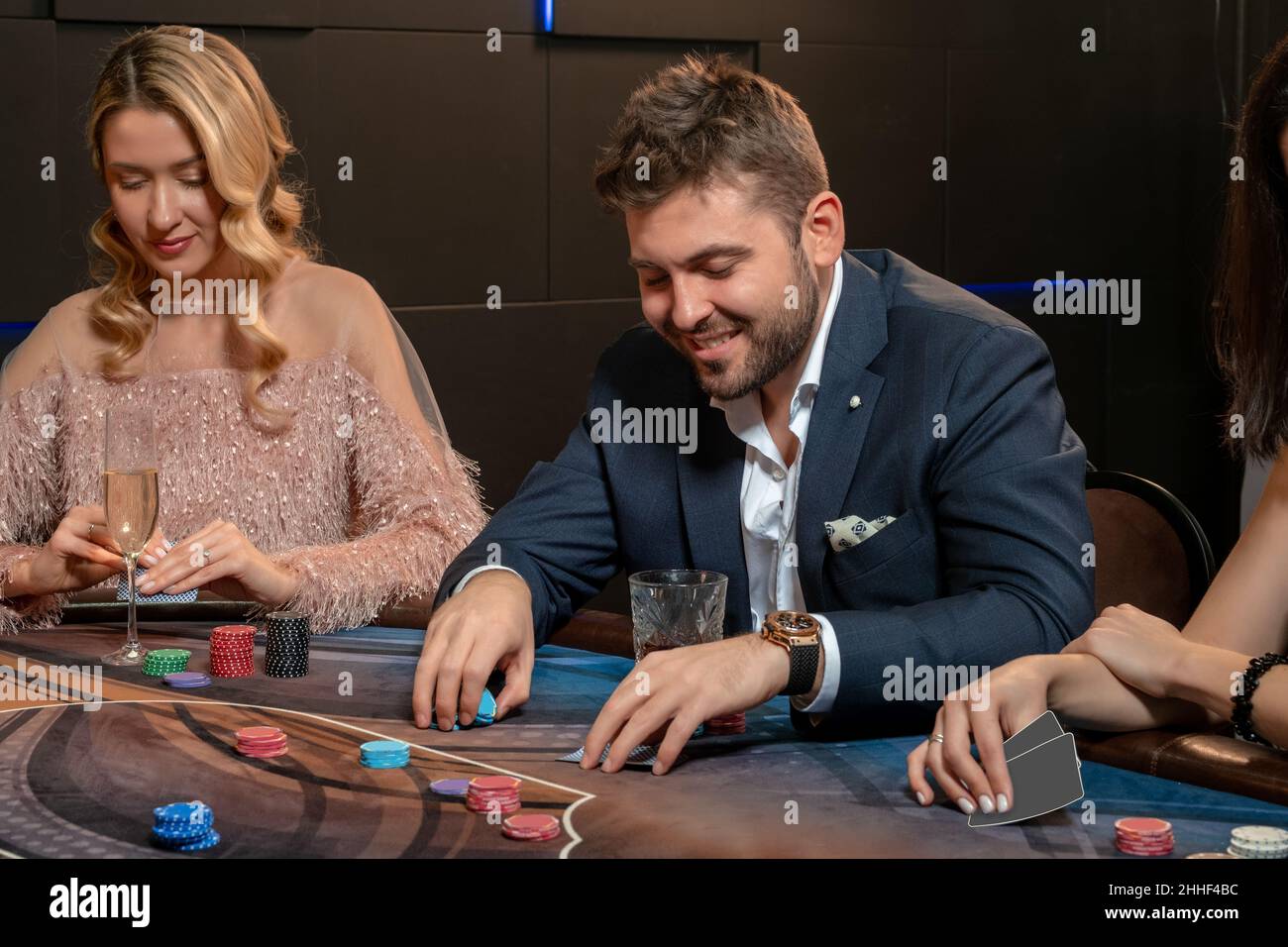 Giovane uomo bearded che fa le scommesse mentre gioca a poker nel casinò Foto Stock